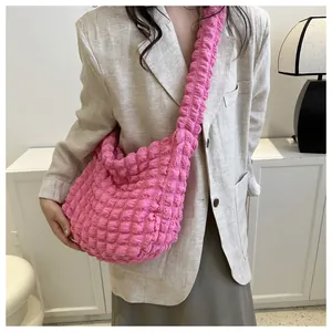 Close-up view of a bright pink bubble cloud bag showing its soft bubble texture and strap