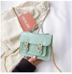 Small light green jelly Cambridge bag with gold chain strap and top handle.
