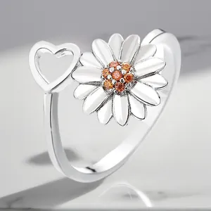 Detail view of silver-plated adjustable daisy ring with heart and orange zircons