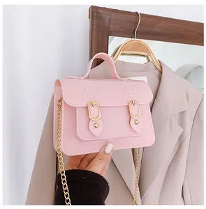 Close-up detail of a stylish pink jelly satchel bag featuring a gold chain strap