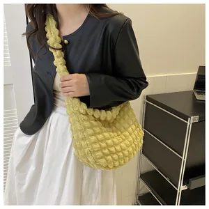 Detailed view of a yellow bubble cloud texture shoulder bag styled with a casual outfit