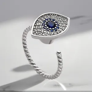 Close-up of a silver adjustable evil eye ring featuring blue and clear zircon stones