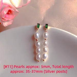 Detail view of elegant freshwater pearl drop earrings with green rectangular stones