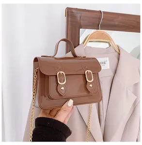 Detailed close-up view of the brown glossy jelly Cambridge bag with golden chain strap
