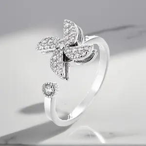 Detailed close-up of a silver-plated rotating windmill ring with sparkling zirconia.