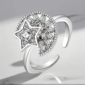 Macro view of a silver rotating ring featuring sparkling star and moon zircon details.