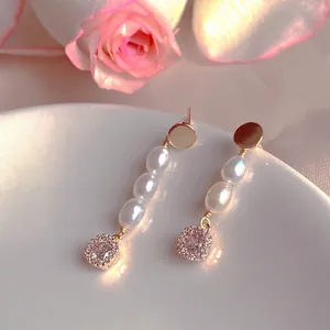 Detail view of elegant freshwater pearl drop earrings with sparkling zircon accents