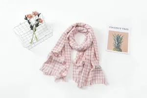 Detailed view of a pink houndstooth plaid scarf with fringes on a clean white background