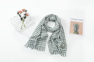 Detail view of green and white houndstooth scarf with soft knitted texture