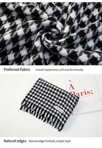 Close-up of black and white houndstooth scarf with fringe details and soft texture