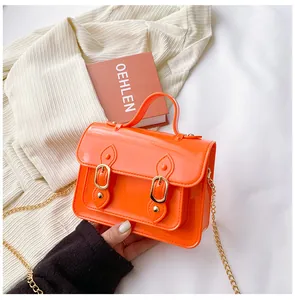 Detail view of a bright orange jelly Cambridge bag with stylish gold chain strap