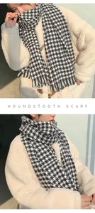 Detail view of a black and white houndstooth scarf with soft fringe edges