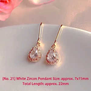 Detailed view of elegant teardrop white zirconia earrings with gold hooks, 22mm total length.