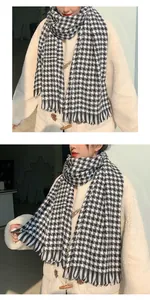 Detail view of a classic black and white houndstooth scarf with tassels for winter.