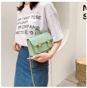 Mint green jelly Cambridge messenger bag held by a model for a fresh summer lifestyle look