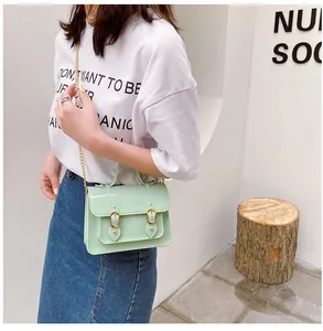 Stylish mint green jelly Cambridge style crossbody bag shown worn with a chain strap
