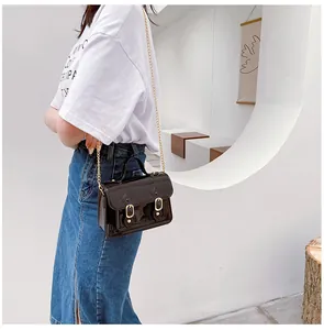 Shiny dark brown Cambridge crossbody bag with gold chain strap detail view