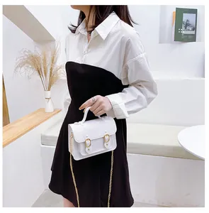 Close-up of a white jelly Cambridge satchel bag with elegant gold chain strap detail