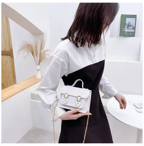 Detailed view of a white jelly Cambridge bag held by a model in a minimal setting