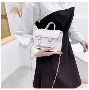 Close-up of a stylish white jelly Cambridge bag with gold chain strap held by a fashion model