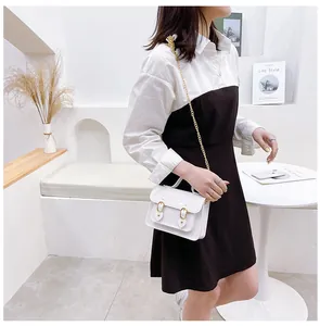Stylish white jelly Cambridge bag with magnetic buckle carried by a model in a minimalist room