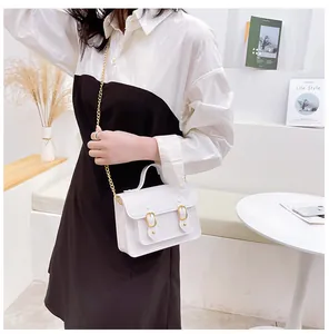 Trendy white jelly Cambridge satchel bag with gold chain strap shown in a lifestyle setting