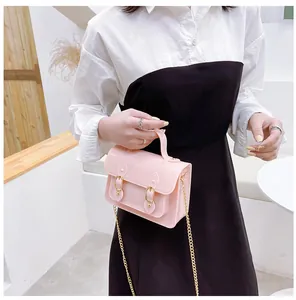 Pink jelly Cambridge bag with gold chain strap held by a model in a chic summer outfit