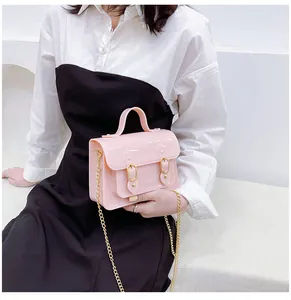 Detailed view of a pink jelly Cambridge satchel bag featuring a gold chain strap