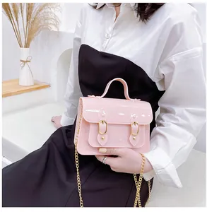 Lifestyle view of a cute pink jelly Cambridge bag with gold chain strap and handle