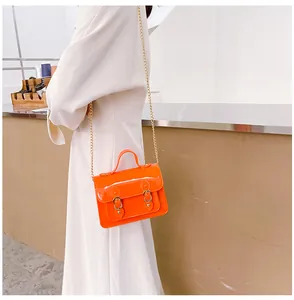 Detailed view of vibrant orange jelly Cambridge bag with gold chain strap