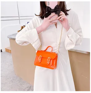 Detailed view of a vibrant orange jelly Cambridge bag with magnetic buckle and gold chain strap