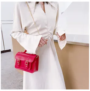 Detail shot of a bright pink jelly Cambridge satchel bag worn with a white dress