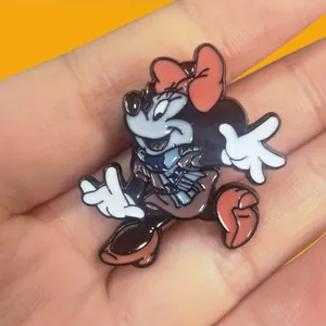 Close-up of a Minnie Mouse enamel pin with pink bow and blue scarf
