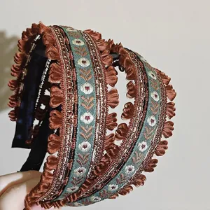 Serre-tête large brodé de style ethnique avec bordure en dentelle florale et détails bleu.