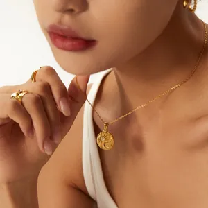 Golden stainless steel coin necklace with sun and moon engraving on female model.