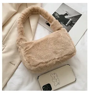 Close-up of beige plush shoulder bag showing compact size comparison with a phone