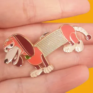 Detailed macro shot of a colorful Slinky Dog metal enamel pin from Toy Story held in hand.