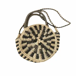 Detailed view of handmade woven round handbag featuring black and white bohemian pattern