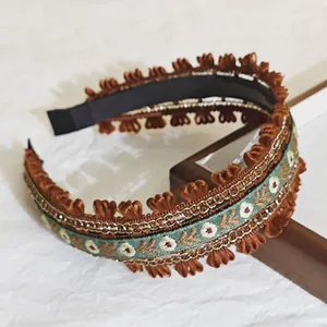 Gros plan d'un serre-tête brodé de style ethnique avec motifs floraux et volants