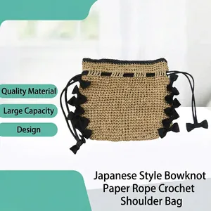 Close-up detail of hand-woven paper rope shoulder bag with elegant black ribbon bow accents
