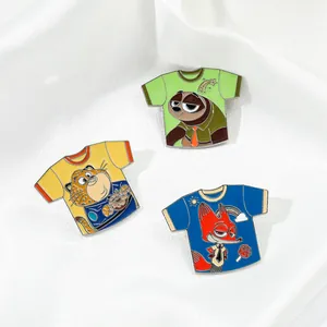 Close-up of three colorful Zootopia enamel pins in mini T-shirt shape on white fabric