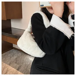 Close-up detailed view of a stylish white fluffy underarm bag worn with a black winter coat