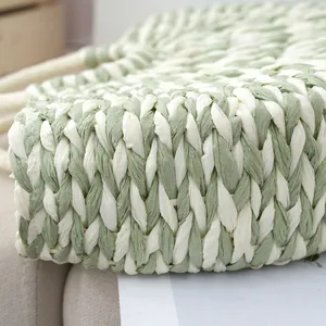 Close-up detail of mixed green and white hand-woven paper straw half-moon handbag