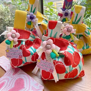 Detailed view of handmade knitted tulip wrist bags with decorative floral charms.
