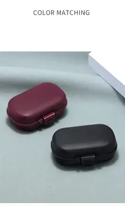 Dettaglio di scatole portapillole in plastica opaca bordeaux e nera con chiusura