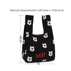 Detailed view of a small knitted gift bag featuring a cute bear pattern and size labels