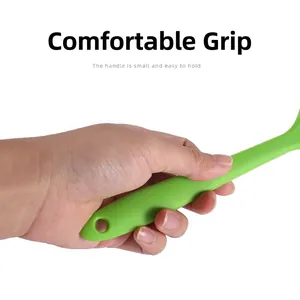 Small green heat-resistant silicone spatula with an ergonomic handle for easy grip