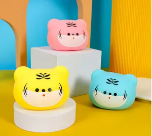 Close-up of vibrant cartoon tiger head squeeze toys in pink, yellow, and blue colors