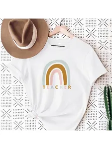 Detailed shot of a rainbow print teacher themed cotton T-shirt hanging on a rack