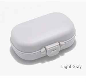 Vista dettagliata del portapillole portatile in plastica grigio chiaro con chiusura